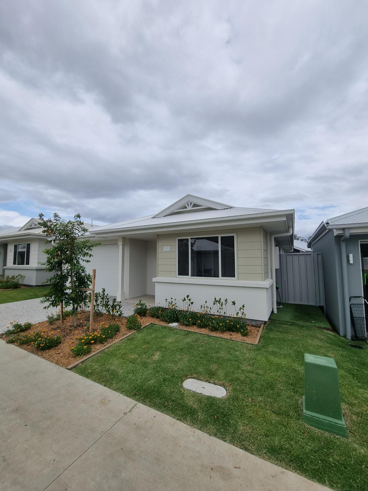 Modern single-story home with a well-maintained lawn and garden.