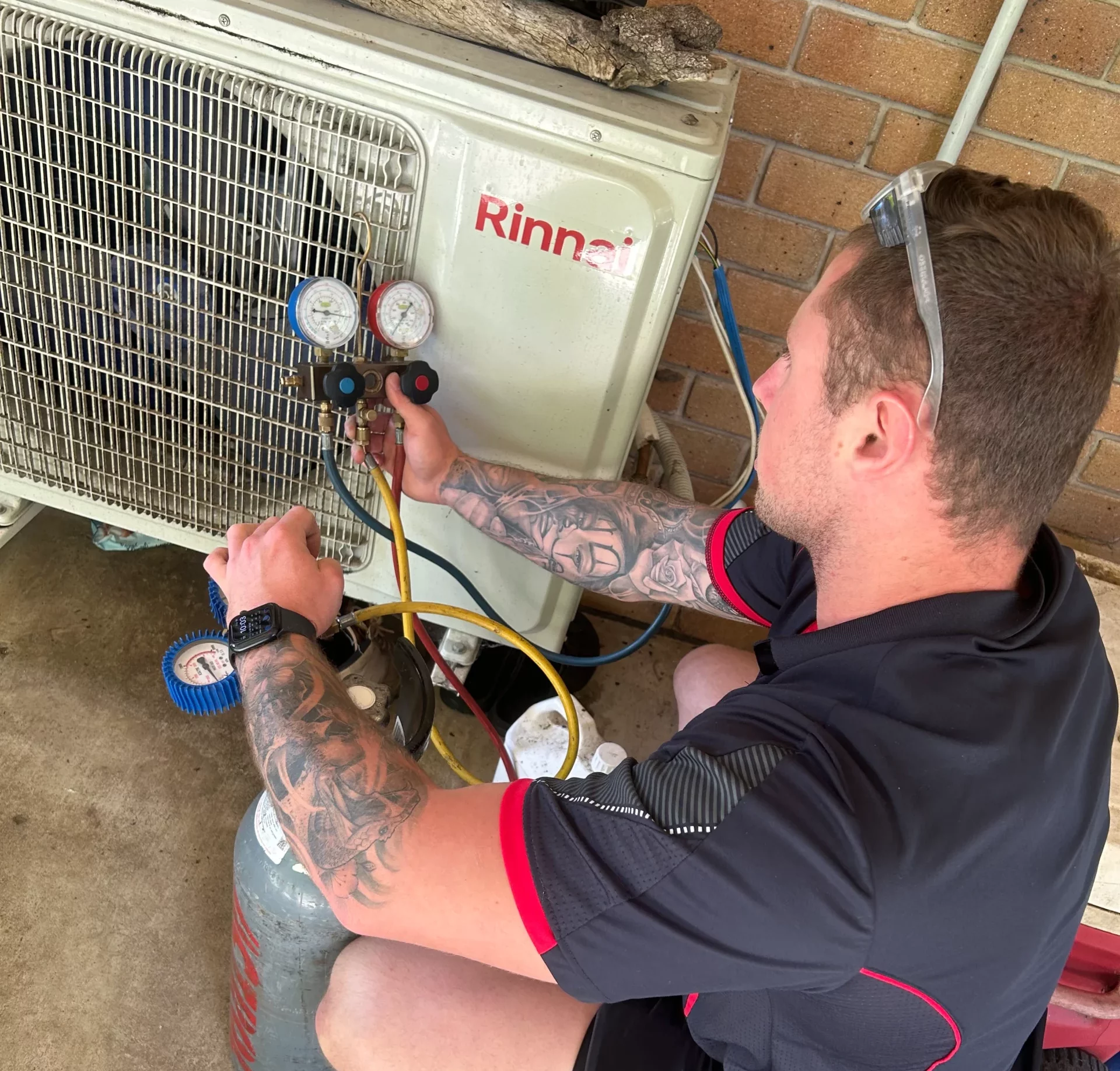 Technician performing air conditioning maintenance and pressure testing in Brisbane to ensure system efficiency.