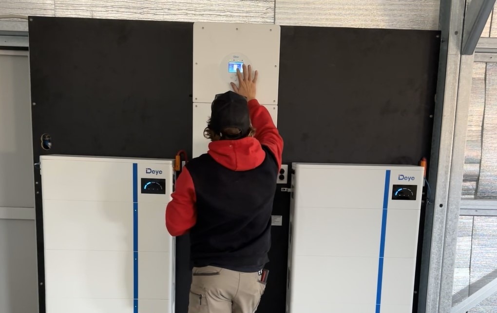 Installer positioning a solar battery unit inside a home, hassle free installations.