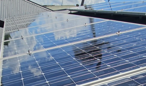 Rooftop solar installation reflecting the sky, captured from a slightly elevated angle
