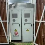 Commercial-grade solar battery and inverter cabinet with high-voltage warning signs, installed outdoors.