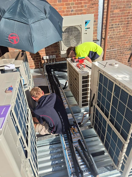 Bright Spark technicians performing detailed repairs on outdoor air conditioning systems, reflecting expert AC repair services.