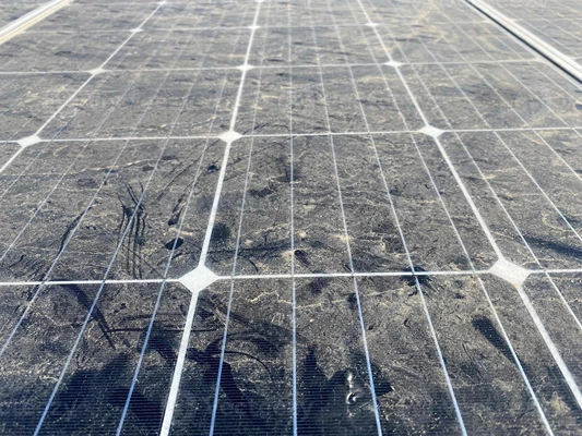 Dust-covered solar panel showing reduced clarity and buildup on the surface.