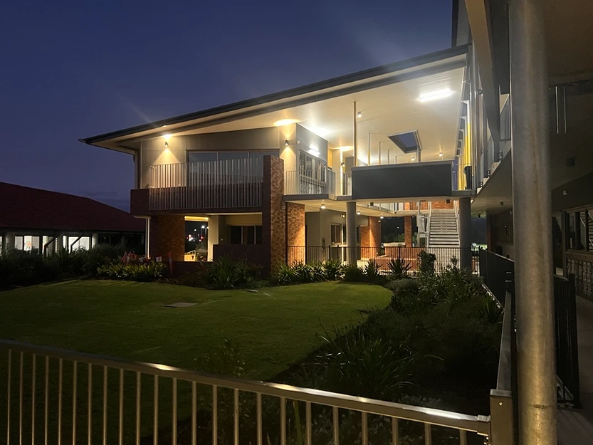 Well-lit modern building exterior at night, demonstrating precise electrical installation and service.