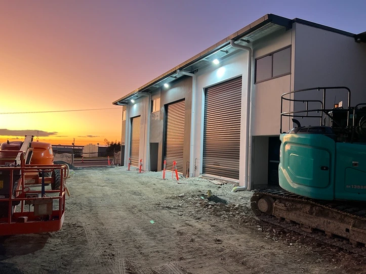 Commercial warehouse construction site at sunset – Queensland commercial electrical services.