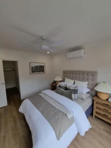 Expertly installed split-system air conditioner and ceiling fan in a modern Brisbane bedroom, ensuring year-round comfort and efficient airflow.