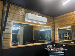 Wall-mounted split system air conditioner installed in a timber-clad Brisbane room, offering targeted, quiet, and energy-efficient cooling for single-room comfort.