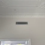Discreet ducted air conditioning ceiling vent inside a home, providing seamless and silent airflow throughout the living space.