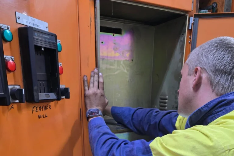 Electrician performing high-voltage maintenance on industrial switchgear, ensuring safe and compliant operation.