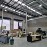 Commercial warehouse interior during electrical fit-out, showcasing structured cabling and workspace preparation.