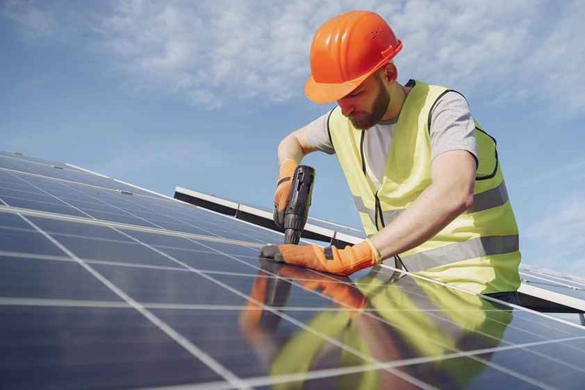 Solar panel technician installing rooftop system under clear skies in Australia