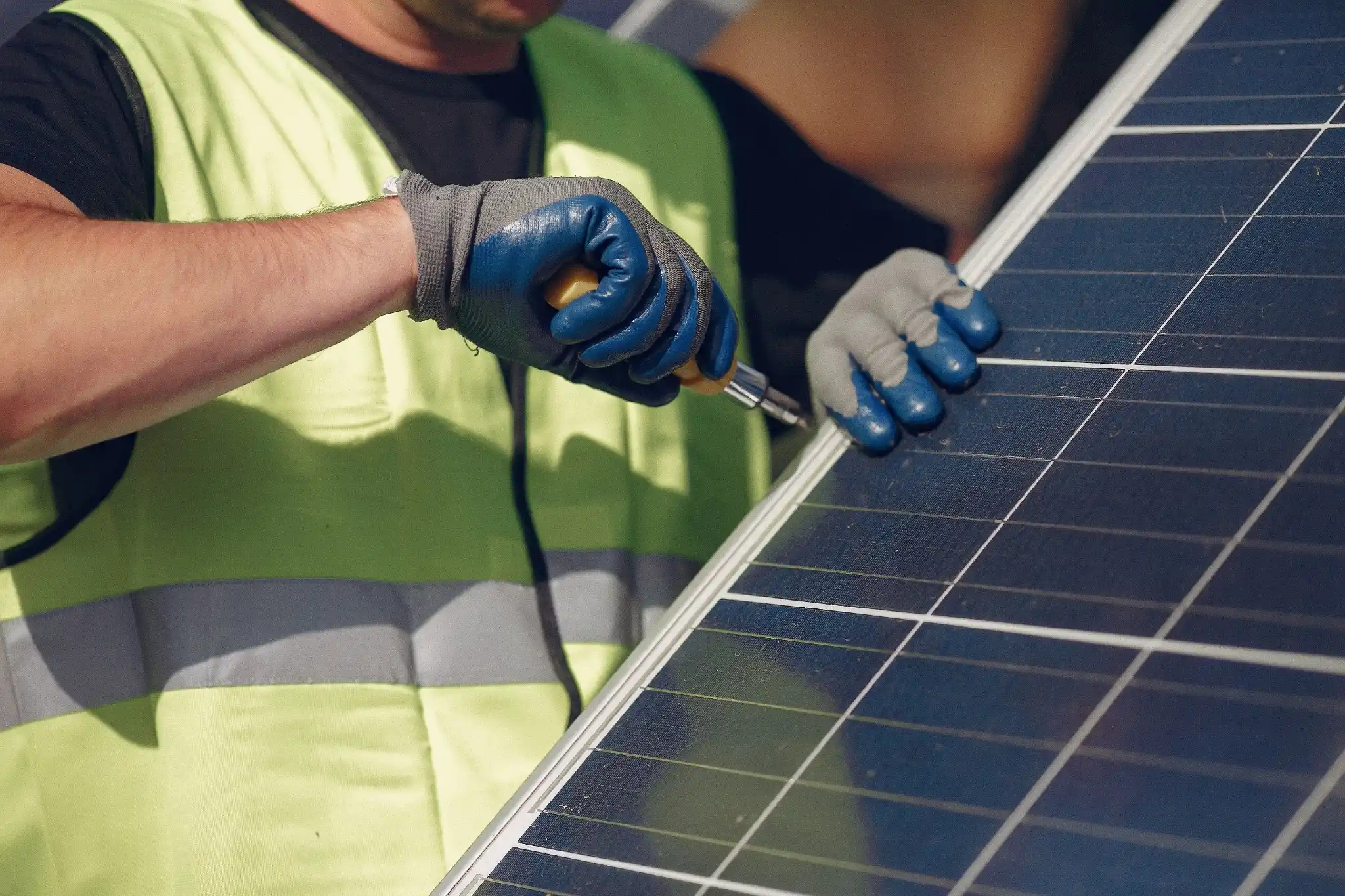 Technician cleaning solar panels as part of routine solar maintenance checklist