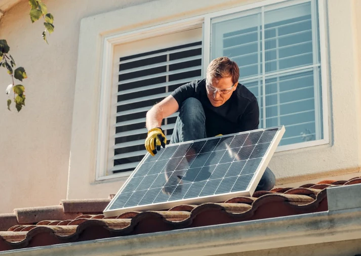 Technician performing solar servicing on rooftop panels