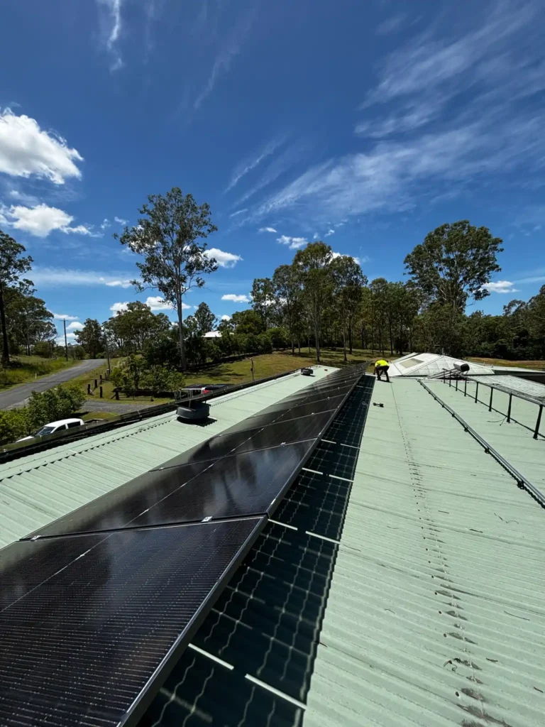 Commercial solar power system installed on green metal roof by Bright Spark Group solar specialists.