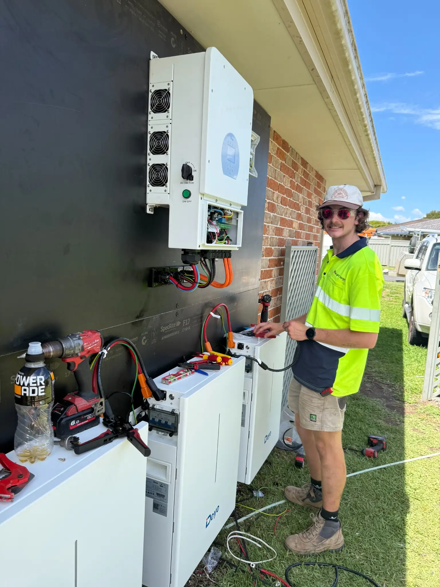 Bright Spark Group solar technician installing Deye inverter and battery storage system.