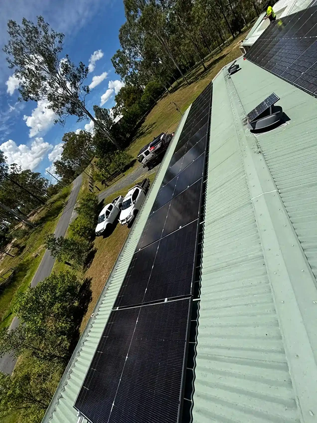 Large-scale rooftop solar array installation by Bright Spark Group on rural commercial property.