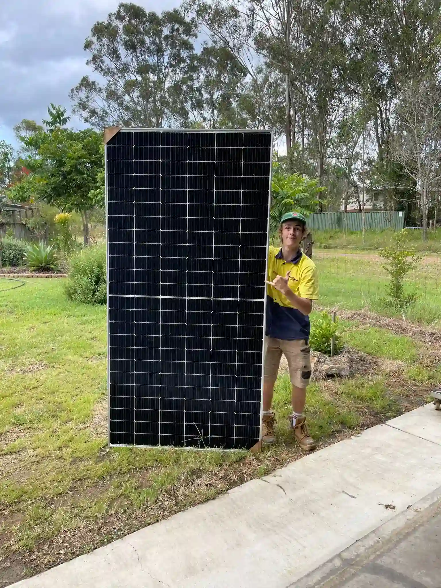 Bright Spark Group solar technician holding high-efficiency solar panel module during installation.
