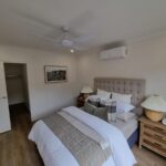Bedroom with a ceiling fan, downlights and a split system air conditioner