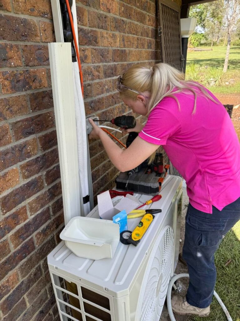 Electrician installing an isolator at an outdoor air conditioning unit