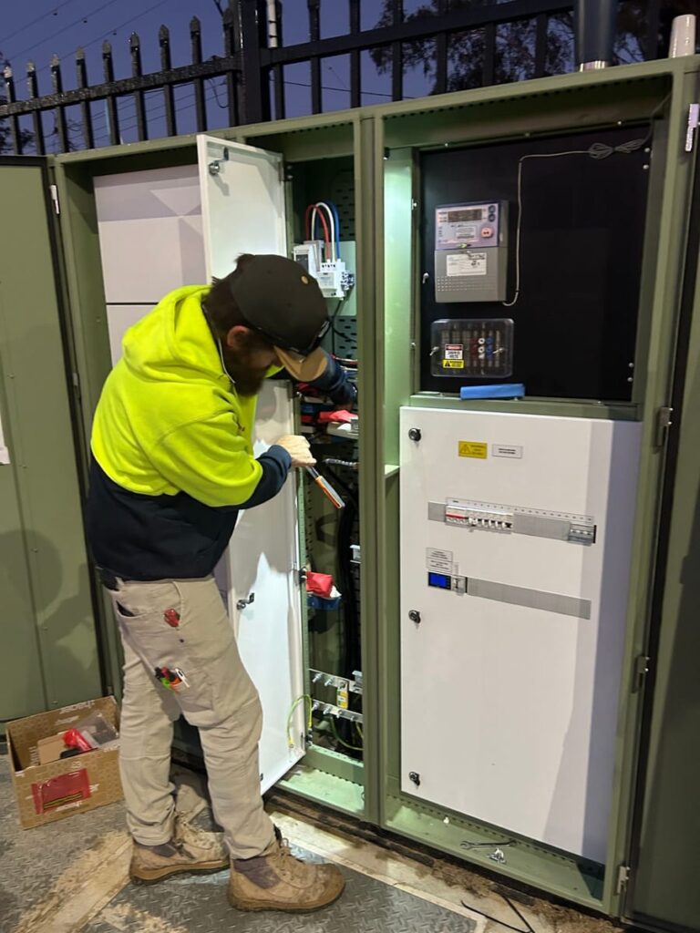 Electrician wiring a main switchboard with a smart meter fitted