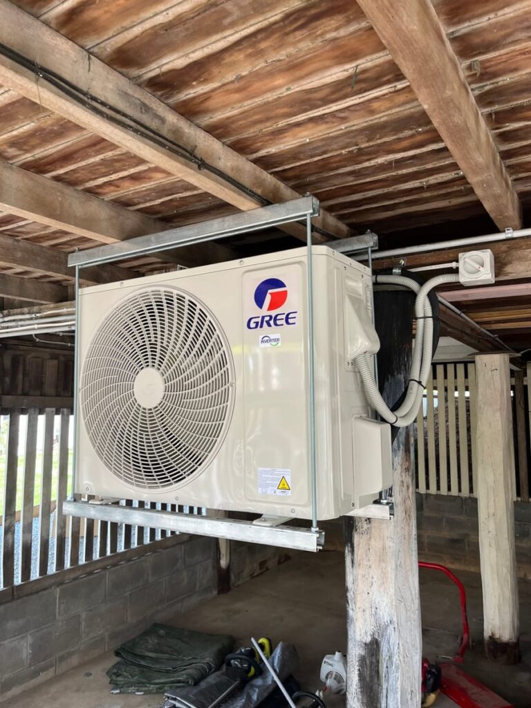 Gree air conditioning outdoor unit mounted on brackets under a high-set Queenslander home