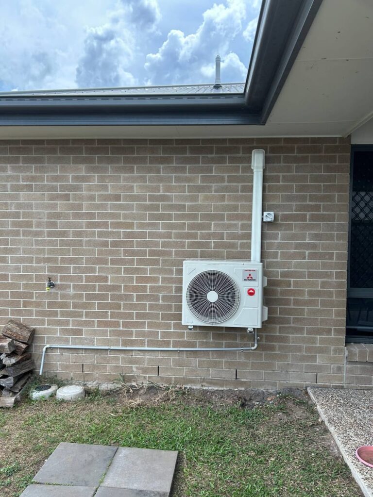 Mitsubishi Heavy Industries outdoor unit neatly installed on a brick home with a white line cover
