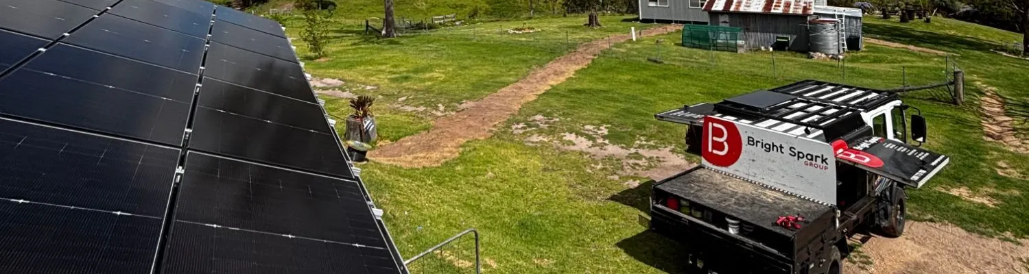Solar panels on an acreage property with a Bright Spark Group truck parked nearby