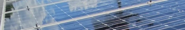 Rooftop solar installation reflecting the sky, captured from a slightly elevated angle