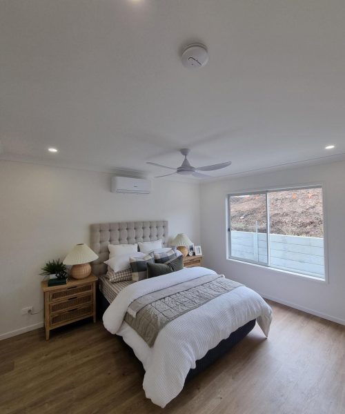 Stylish bedroom with a cozy bed, wooden flooring, and natural lighting.