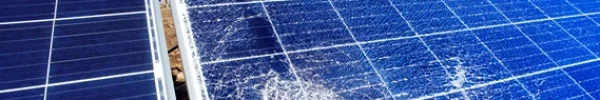 Close-up of a damaged solar panel with visible cracks and shattered glass.