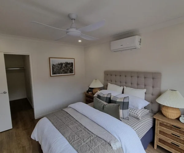 Expertly installed split-system air conditioner and ceiling fan in a modern Brisbane bedroom, ensuring year-round comfort and efficient airflow.