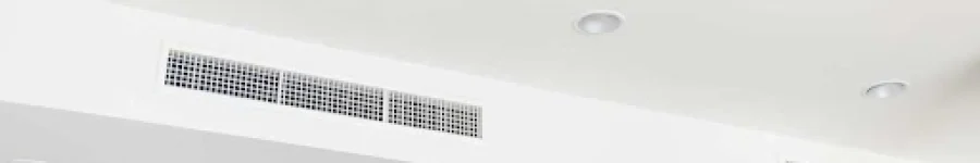 White ceiling with recessed lighting, air conditioning vents, and a fire sprinkler.