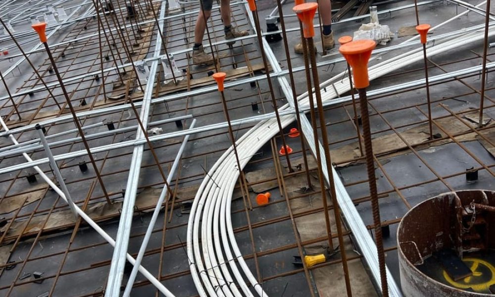 Electrical conduits laid out on a concrete slab during construction