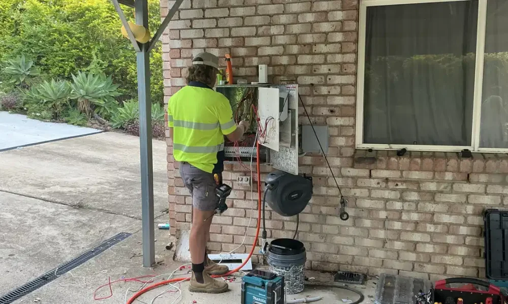 Bright Spark Group electrician working on outdoor power installation at a Queensland home
