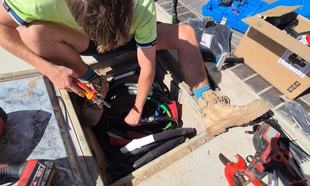 Electrician terminating underground cables in a pit